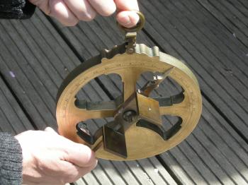 Holding the astrolabe for observations.